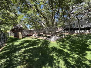 Fenced backyard featuring a playground