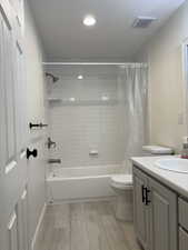 Bathroom featuring shower / tub combo, vanity, light wood-style floors, and recessed lighting
