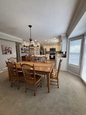 Dining area with ornamental molding, light carpet, a textured ceiling, a chandelier, and recessed lighting