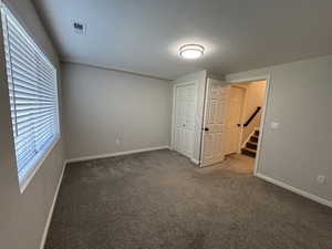 Unfurnished bedroom featuring carpet and a closet