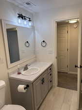 Half bathroom featuring vanity and light wood-style flooring