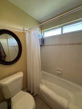 Full bath featuring shower / bathtub combination with curtain and tile patterned floors