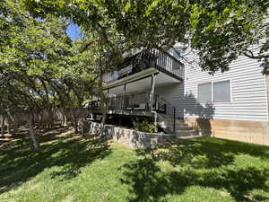 Back of property with a lawn and stairs