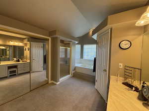 Full bath featuring a garden tub, a stall shower, vanity, and light carpet