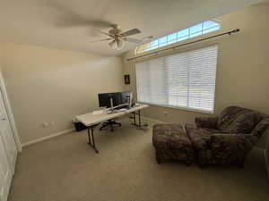 Carpeted office with a textured ceiling and ceiling fan