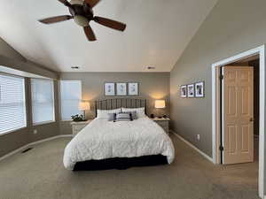 Bedroom with vaulted ceiling, carpet, a textured ceiling, and a ceiling fan