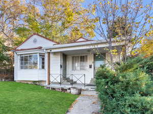 Bungalow with a front lawn and covered porch