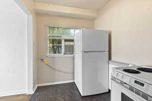 Kitchen featuring white appliances and baseboards