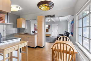 Kitchen featuring light brown cabinets, light wood finished floors, beam ceiling, and freestanding refrigerator