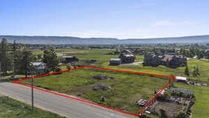 Aerial overview of property's location with property parcel outlined and a mountainous background