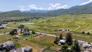 Aerial view of property and surrounding area with a water and mountain view and nearby suburban area