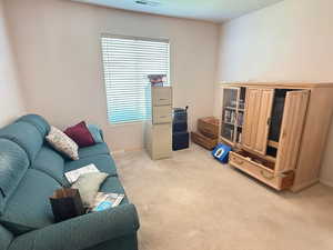 Sitting room with light colored carpet and baseboards