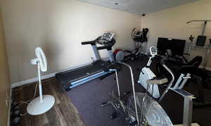 Workout room with wood finished floors and a textured ceiling