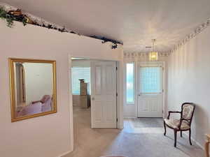 Doorway with carpet, tile patterned flooring, and a textured ceiling
