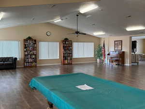 Playroom featuring dark wood-style flooring, a textured ceiling, lofted ceiling, ceiling fan, and pool table