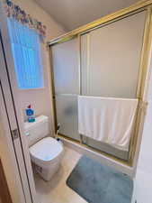 Bathroom with a shower stall and toilet