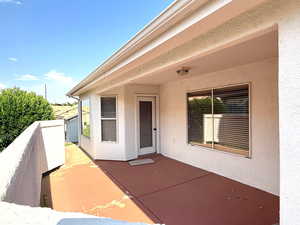 Property entrance featuring stucco siding and a patio