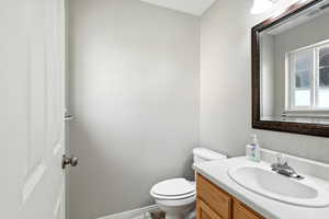 Half bathroom with vanity and toilet