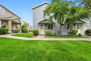 View of front facade with a front yard and stucco siding