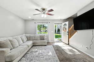 Living area with carpet, stairs, recessed lighting, and ceiling fan