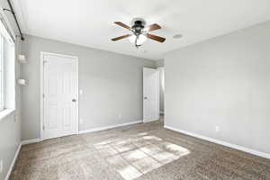 Unfurnished bedroom featuring carpet floors and a ceiling fan