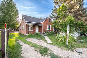 Bungalow-style home with roof with shingles, a front yard, and a porch
