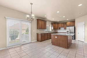 Kitchen featuring a center island, light tile patterned floors, decorative backsplash, a chandelier, and recessed lighting