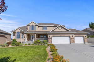 View of front of house with covered porch, an attached garage, concrete driveway, a front lawn, and stucco siding
