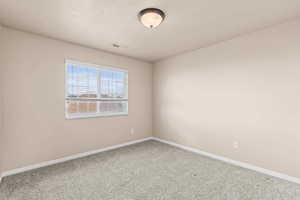 Spare room featuring baseboards and carpet floors