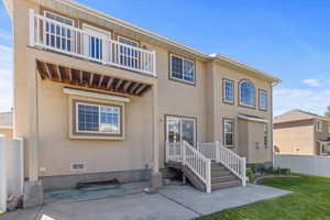 Rear view of house featuring stucco siding, crawl space, and a balcony