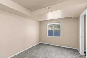 Carpeted empty room featuring baseboards