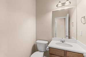 Half bath featuring vanity and toilet