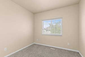 Carpeted spare room with baseboards