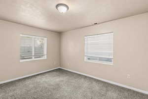 Empty room featuring carpet floors and a textured ceiling