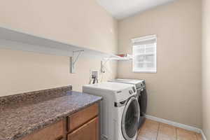 Laundry room featuring light tile patterned floors and washing machine and dryer