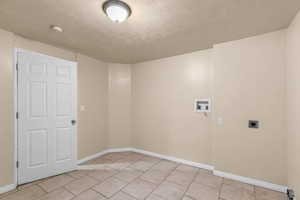 Laundry area with a textured ceiling, washer hookup, and hookup for an electric dryer