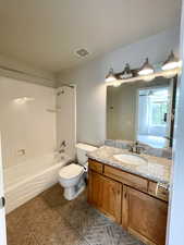 Bathroom featuring shower / bathtub combination, vanity, and light tile patterned floors