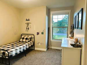 Bedroom featuring light carpet and baseboards