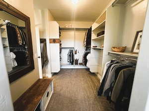 Spacious closet with dark carpet