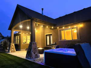 Back of property with a patio, stucco siding, and an outdoor fire pit