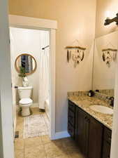 Full bath with shower / bath combo, vanity, and light tile patterned floors
