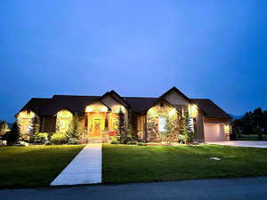 Craftsman inspired home with stone siding, a front yard, a garage, and driveway