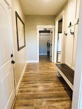 Corridor with light wood-style flooring and separate washer and dryer