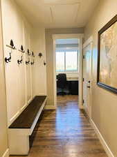 Mudroom with dark wood finished floors and built in desk
