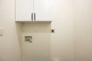 Main Laundry room with cabinet space, hookup for a washing machine, and hookup for an electric dryer