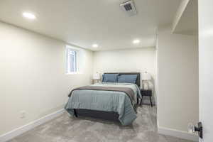Bedroom with light carpet and recessed lighting