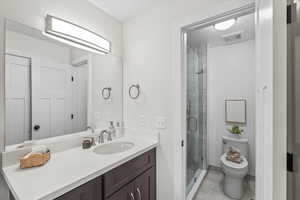 Bathroom with vanity, a shower stall, and light tile patterned floors
