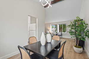 Dining room featuring light wood-style floors and a towering ceiling