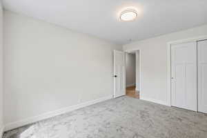 Unfurnished bedroom with carpet and a closet