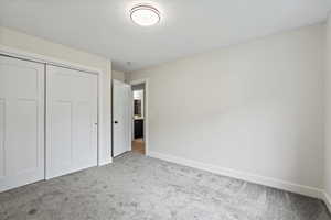 Unfurnished bedroom featuring a closet, carpet, and a textured ceiling